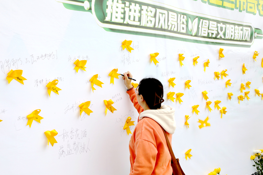 4月3日，廣昌縣廣大群眾在蓮花廣場將黃絲帶粘貼在追思牆上，用一束鮮花表達對故人的思念，並依次在追思牆上簽下自己的名字和祈福詞。地方供圖