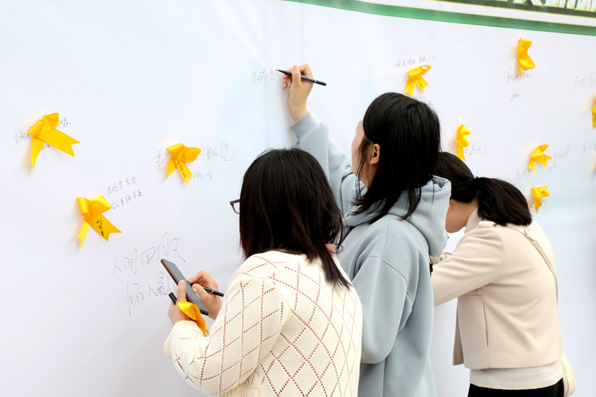 4月3日，廣昌縣廣大群眾在蓮花廣場將黃絲帶粘貼在追思牆上，用一束鮮花表達對故人的思念，並依次在追思牆上簽下自己的名字和祈福詞。地方供圖