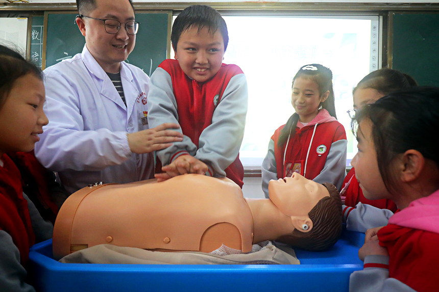 孩子們在醫護人員指導下進行心肺復蘇練習。何賤來攝