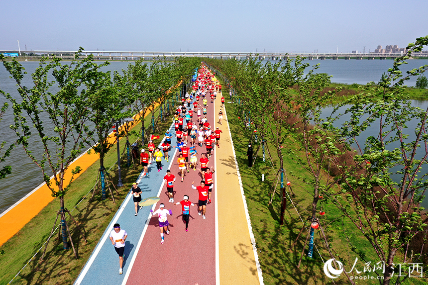 2023“廬山杯”九江馬拉鬆在江西省九江市八裡湖新區鳴槍開跑。圖為跑友們在環賽城湖的綠道上奔跑。 人民網 時雨攝