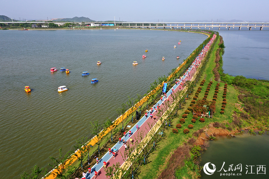 2023“廬山杯”九江馬拉鬆在江西省九江市八裡湖新區鳴槍開跑。圖為跑友們在環賽城湖的綠道上奔跑。 人民網 時雨攝