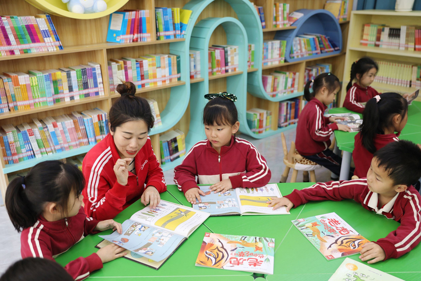 城市書屋內，第四幼兒園的老師正在指導孩子們閱讀繪本書籍。陳旗海攝