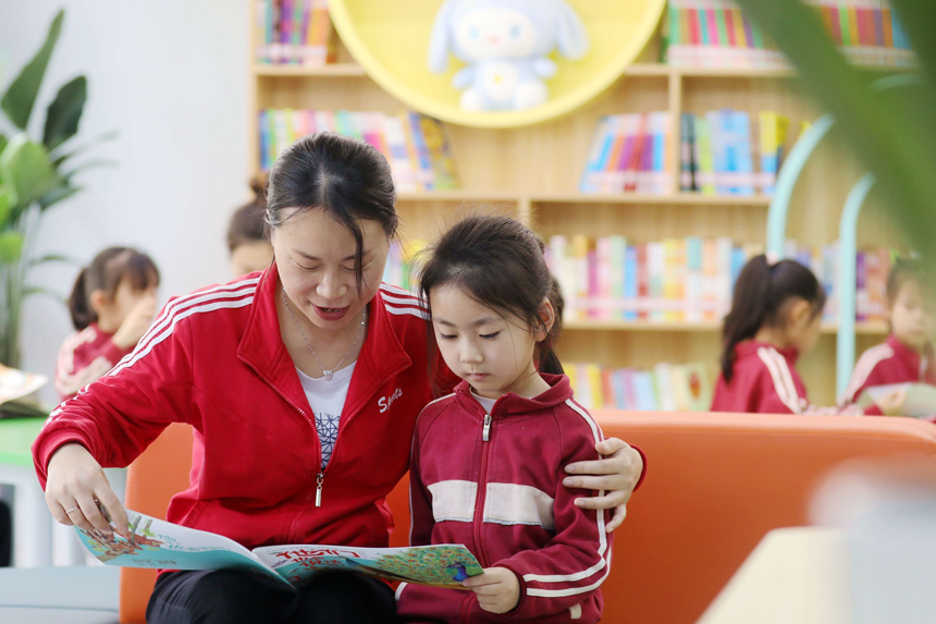 城市書屋內，第四幼兒園的老師正在指導孩子們閱讀繪本書籍。陳旗海攝
