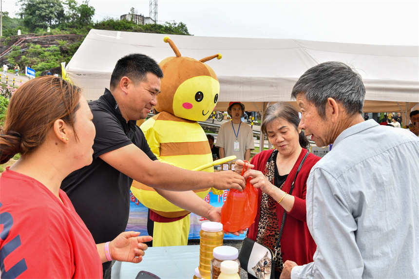 蜂蜜展销会上，游客正在购买蜂蜜。 黄洋摄