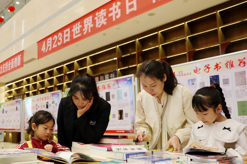 4月22日，市民在江西省宜春市上高縣圖書館裡挑選、閱讀書籍。陳旗海攝