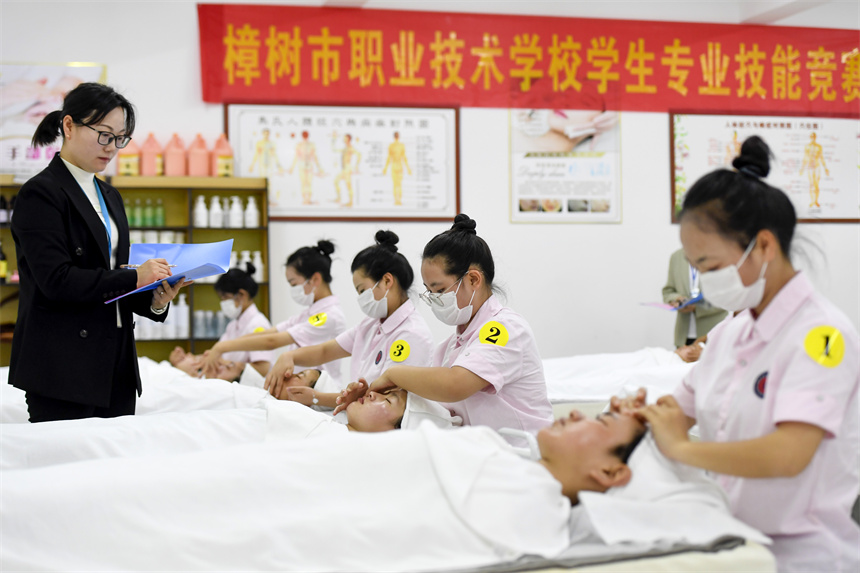 學生在實訓室進行美容技能競賽。周亮攝