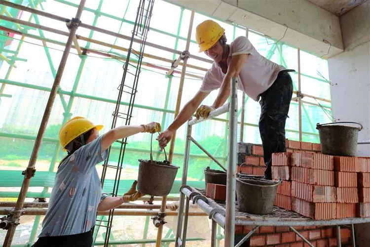 在贛州牡丹亭路小學項目建設現場，工人們正忙著砌牆。歐艷芬攝