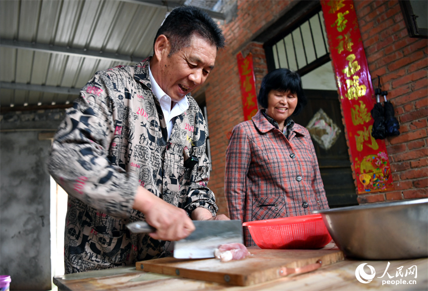 廖連榮正在切肉，鬆湖米粉肉需選用上好的五花肉。 人民網記者 時雨攝