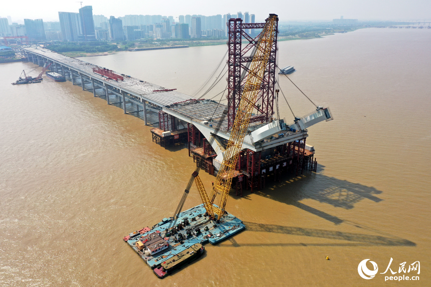 复兴大桥旁的江面上600吨的浮吊正在安装拱肋。 人民网记者 时雨摄