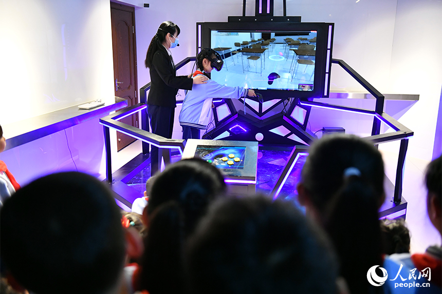 学生通过VR穿戴设备体验灾难现场逃生。 人民网记者 时雨摄