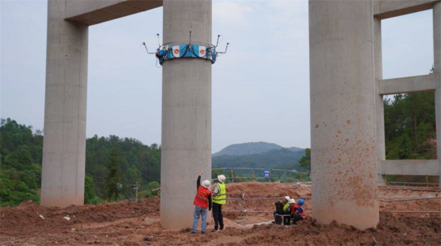 “高墩机器人”正在对桥墩进行检测，检测人员密切关注数据。 张强旺摄