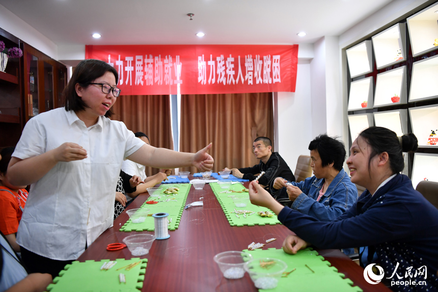 殘疾人學員制作完手工品后，培訓老師點贊鼓勵。人民網記者 時雨攝