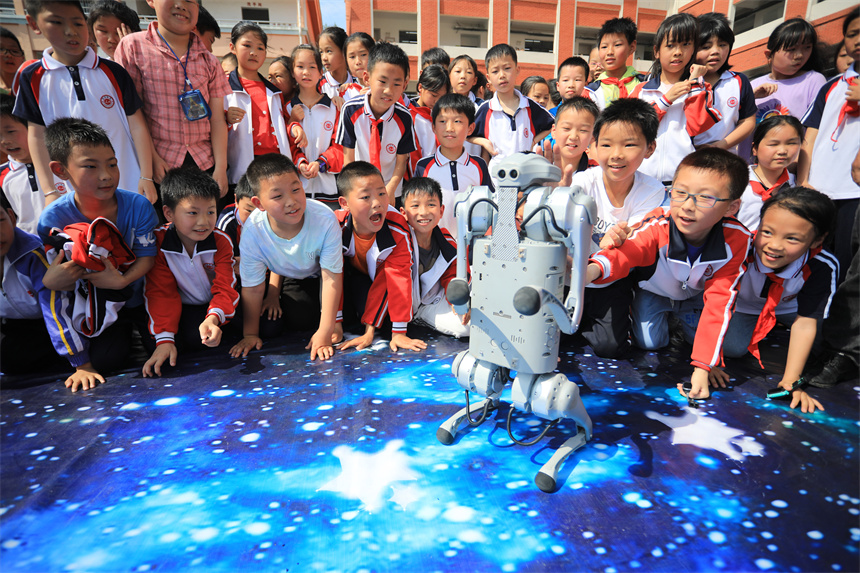 近日，在江西省抚州市乐安县第三小学操场上，学生们正在观看机械狗表演。邱志超摄