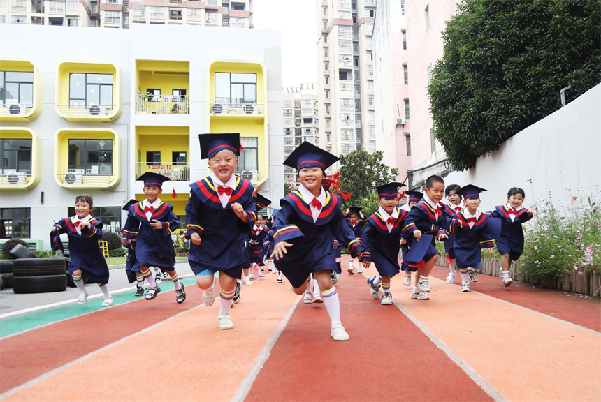 幼兒園師生們擺出創意造型，拍攝校園畢業照。 饒方其攝