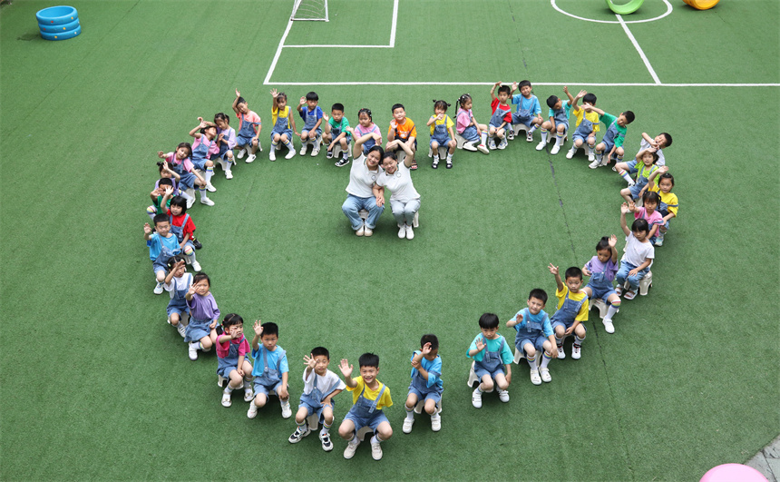 幼兒園師生們擺出創意造型，拍攝校園畢業照。 饒方其攝