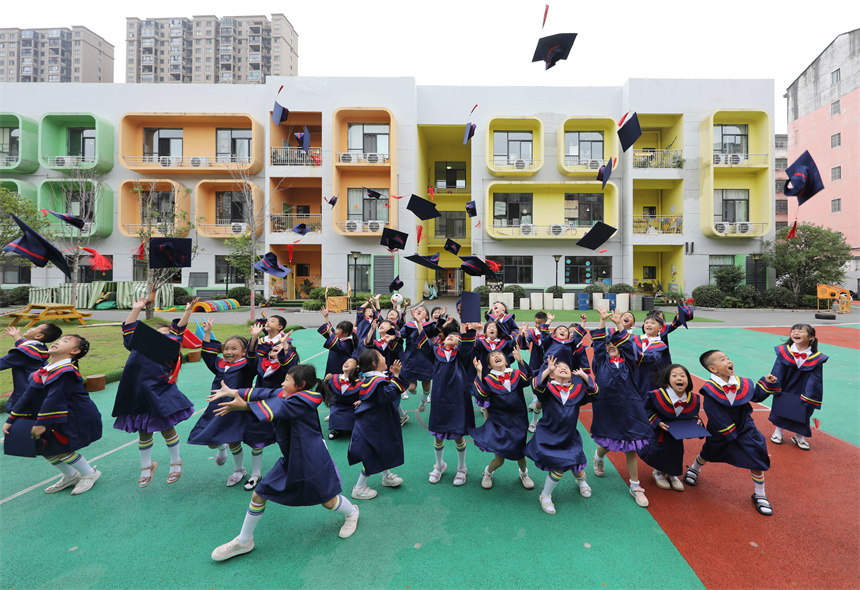 幼兒園師生們擺出創意造型，拍攝校園畢業照。 饒方其攝
