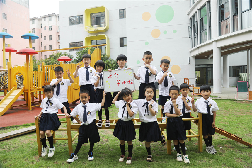 幼兒園師生們擺出創意造型，拍攝校園畢業照。 饒方其攝