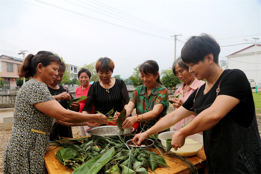村民們圍在一起包粽子。