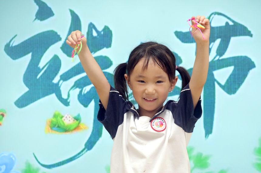 位于宜丰县崇文社区的宜丰第二幼儿园（崇文园），小女孩展示编制的五彩丝线。何贱来摄