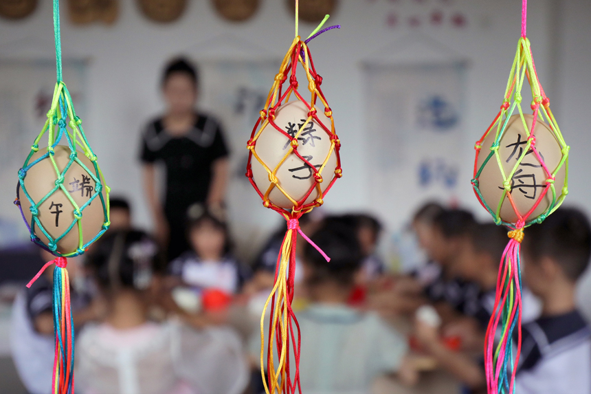 位于江西省宜丰县城西社区的宜丰第三幼儿园，孩子们在老师指导下编制彩蛋绳网。何贱来摄