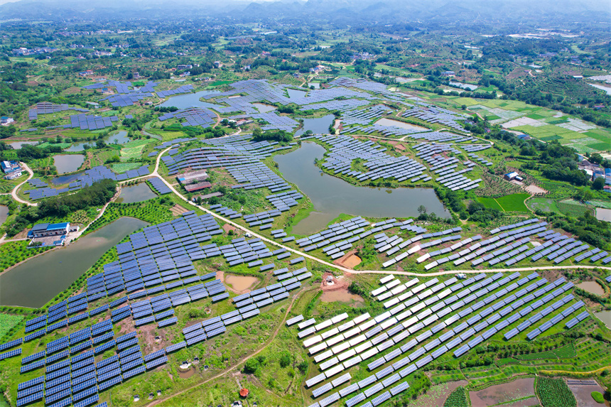 一排排光伏發電板與農居、田園相映成趣，呈現一派鄉村振興的美景。楊鑫攝