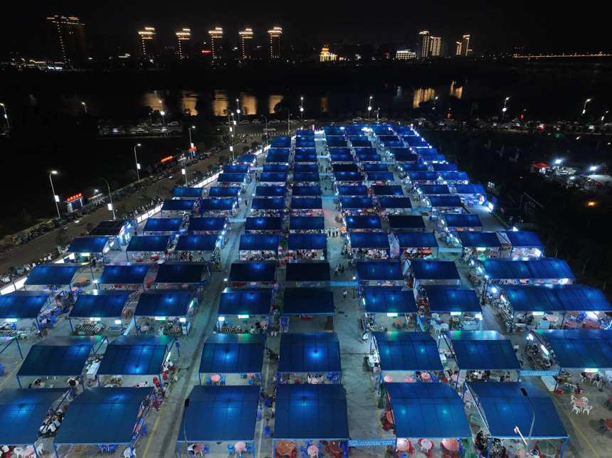 从航拍镜头看，夜市摊位排列整齐，井然有序。刘驭摄