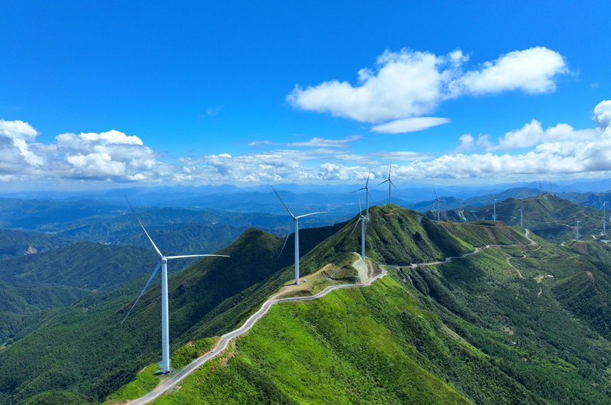 风力发电机组与连绵的青山构成了一幅夏日美景图。李建平摄