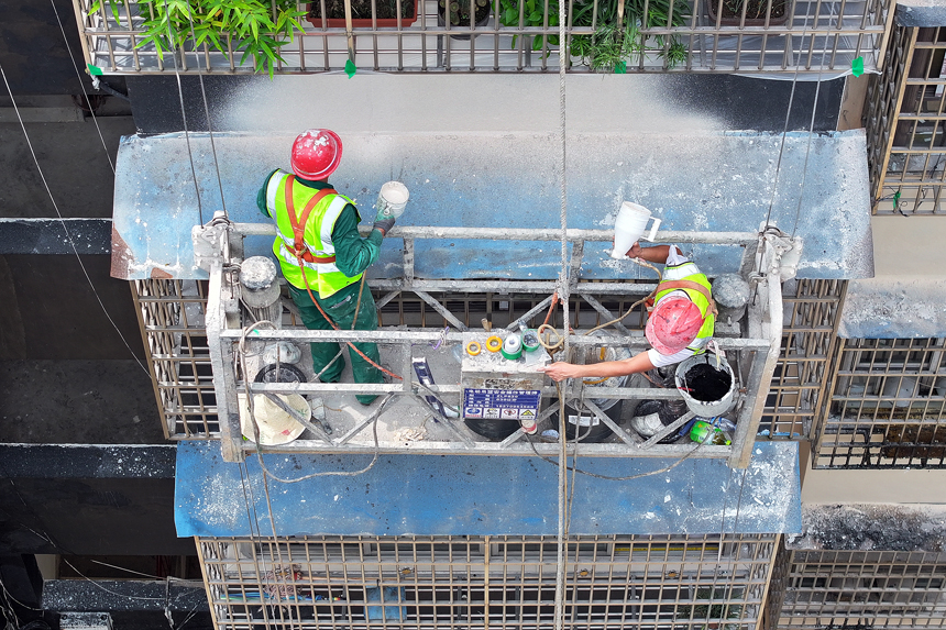施工人员在宜丰县综投集团城投公司承建的耶溪社区商务老旧小区进行外立面改造作业。刘红燕摄