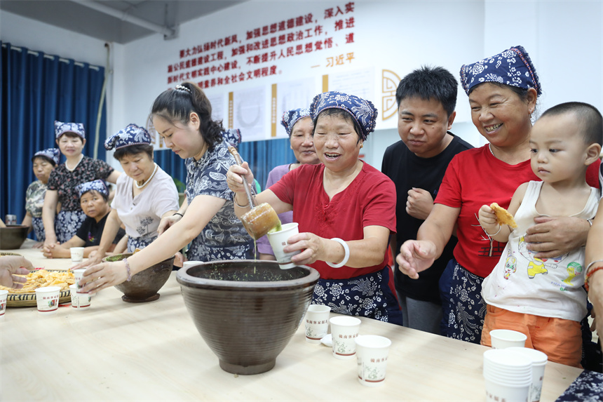 社区居民们现场体验擂茶制作过程。钟万汕摄