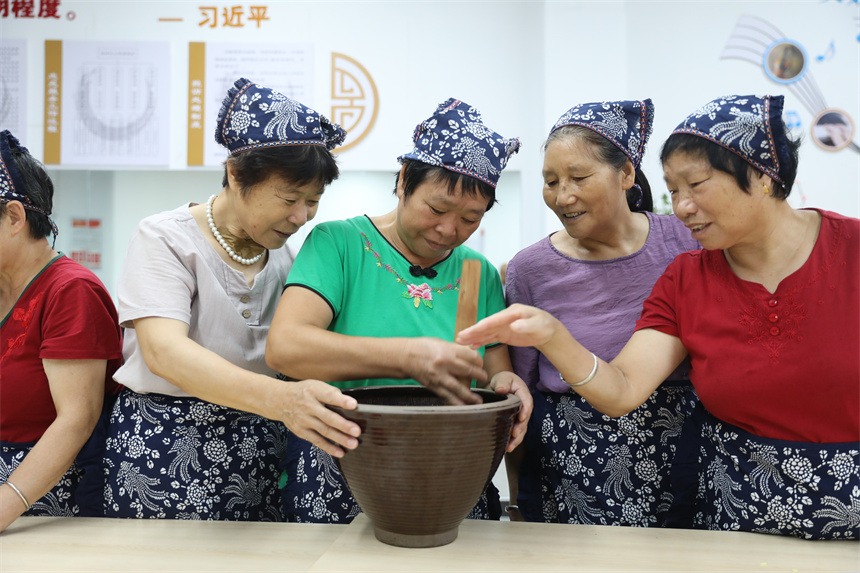 社区居民们现场体验擂茶制作过程。钟万汕摄