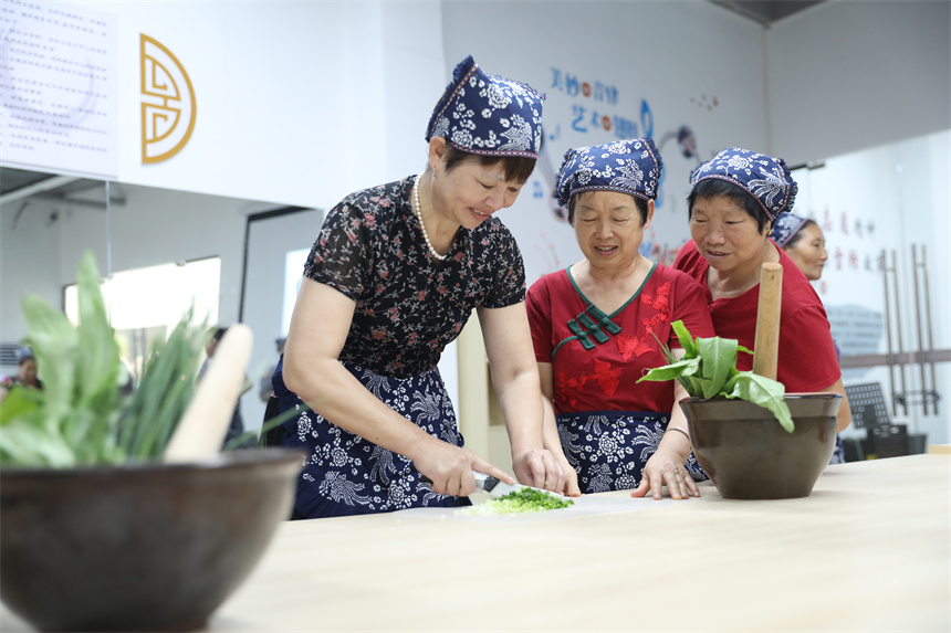 社区居民们现场体验擂茶制作过程。钟万汕摄