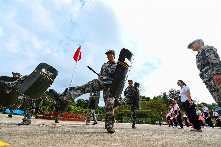 少先隊員在觀摩民兵隊員訓練。