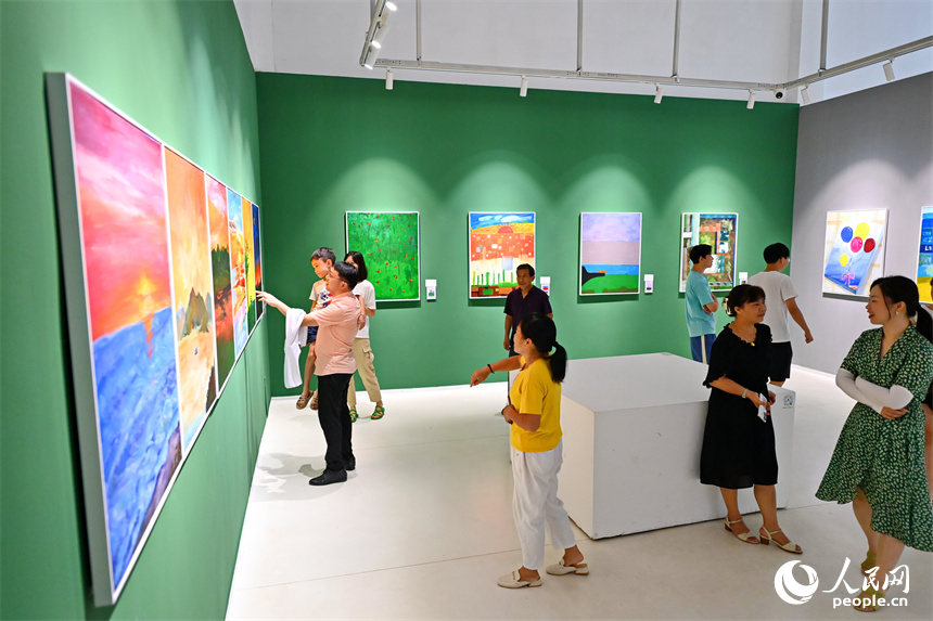 在萍鄉市湘東區江口村的零799藝術區藝術展廳裡，游客在參觀本土畫家創作的油畫作品。人民網 朱海鵬攝