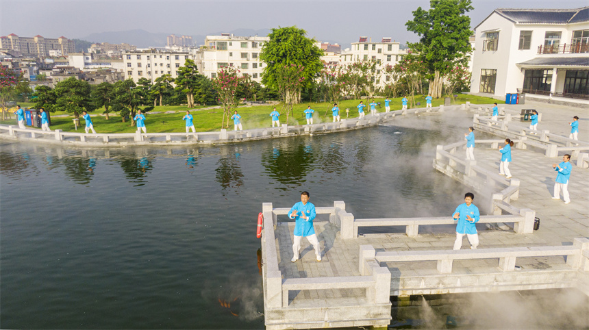 近日，在“定南之窗”商贸文旅综合体湖畔，太极拳爱好者正在练习太极拳。詹继成摄