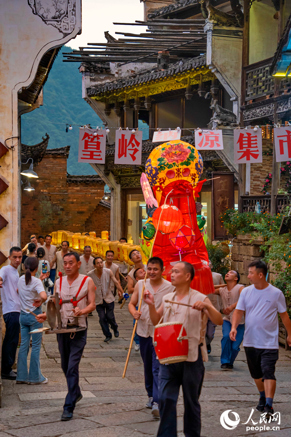 婺源县篁岭村，村民舞起200多米长的板凳龙灯，庆祝丰收季的到来。人民网 朱海鹏摄