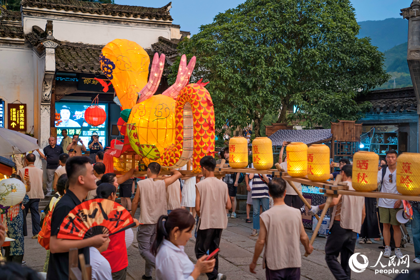 婺源县篁岭村，村民舞起200多米长的板凳龙灯，庆祝丰收季的到来。人民网 朱海鹏摄