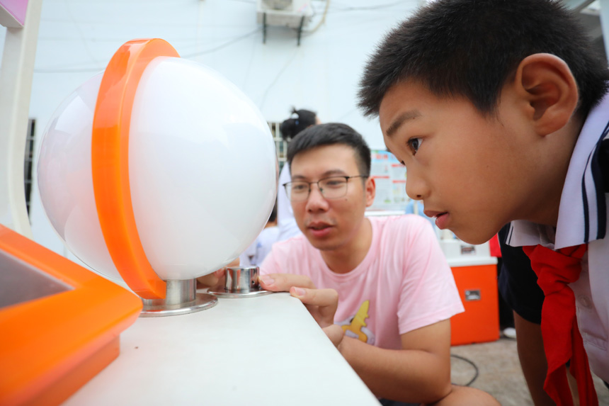 学生们正在科普老师的指导下体验有趣的科学实验。邱志超摄