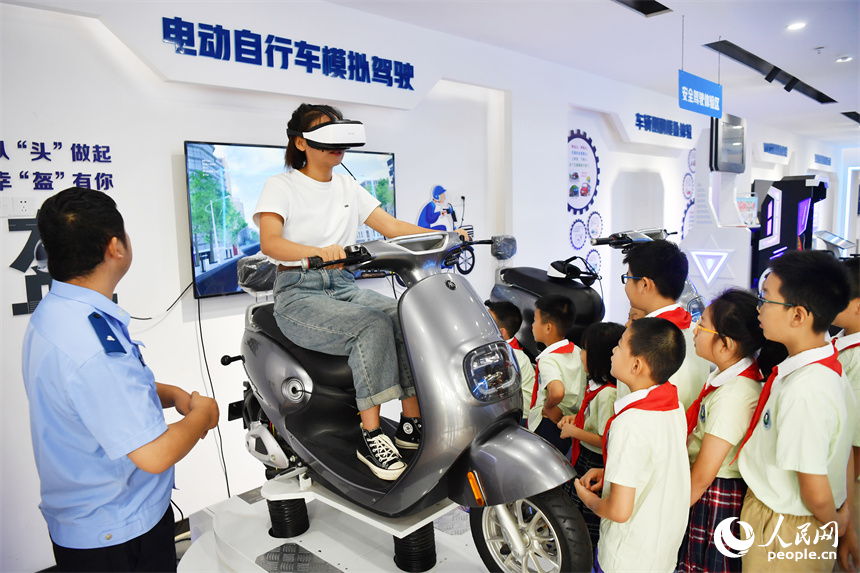 家長戴上VR眼鏡，通過動感仿真平台進行安全騎行的體驗。 人民網記者 時雨攝