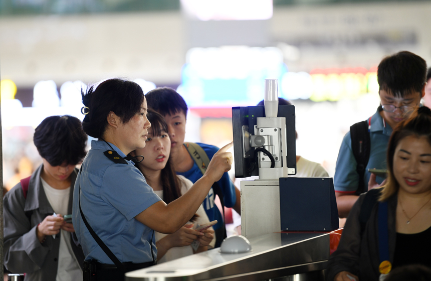 8月31日，在南昌火车站，工作人员正在帮助旅客验票进站。 胡国林摄