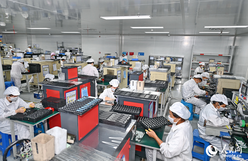 近日，锂电新能源电池生产企业内，工人在操作电子设备赶制电池产品订单。人民网 朱海鹏摄