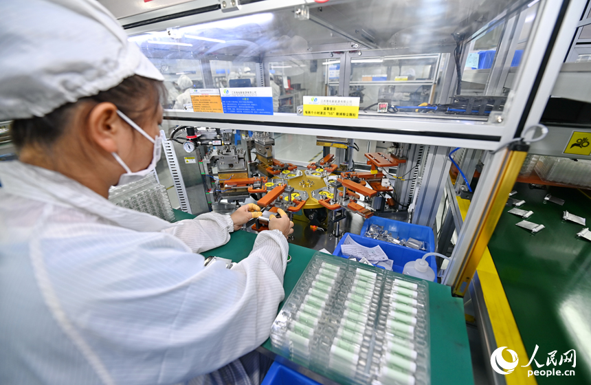近日，锂电新能源电池生产企业内，工人在操作电子设备赶制电池产品订单。人民网 朱海鹏摄
