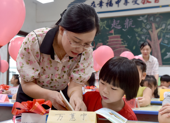 老师正与新生一起识图认字。