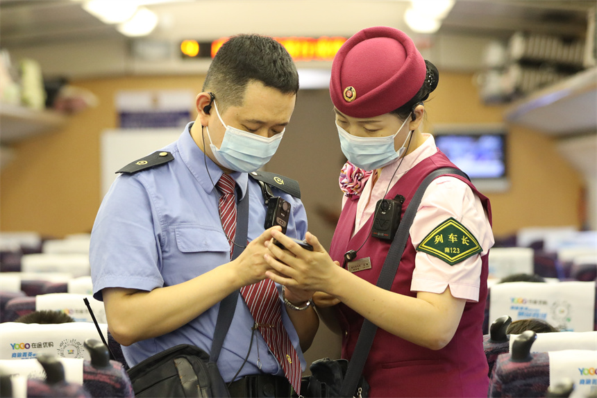 南鐵南昌客運段D6504次列車長王璐正在與列車安全員核對旅客席位信息。丁波攝