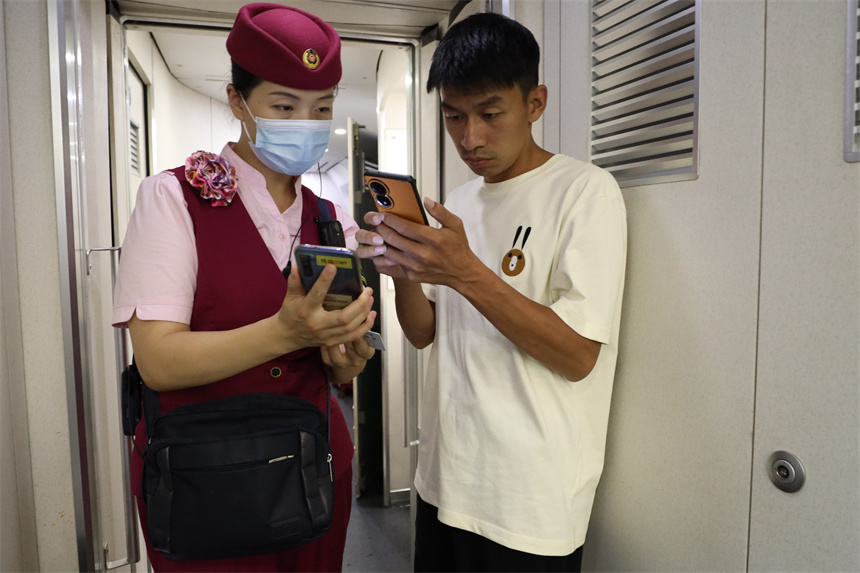南昌客運段D6504次列車長王璐正在為旅客辦理補票。丁波攝