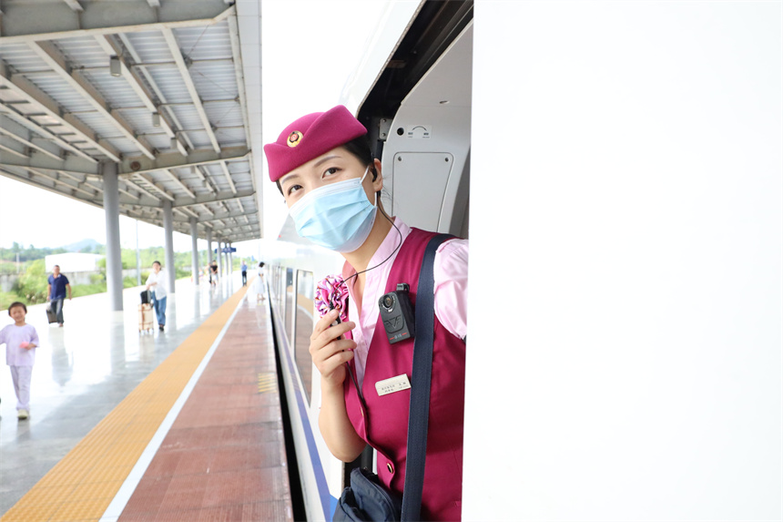 南昌客運段D6504次列車長王璐正在進行瞭望，確保開車前安全鎖閉車門。 丁波攝