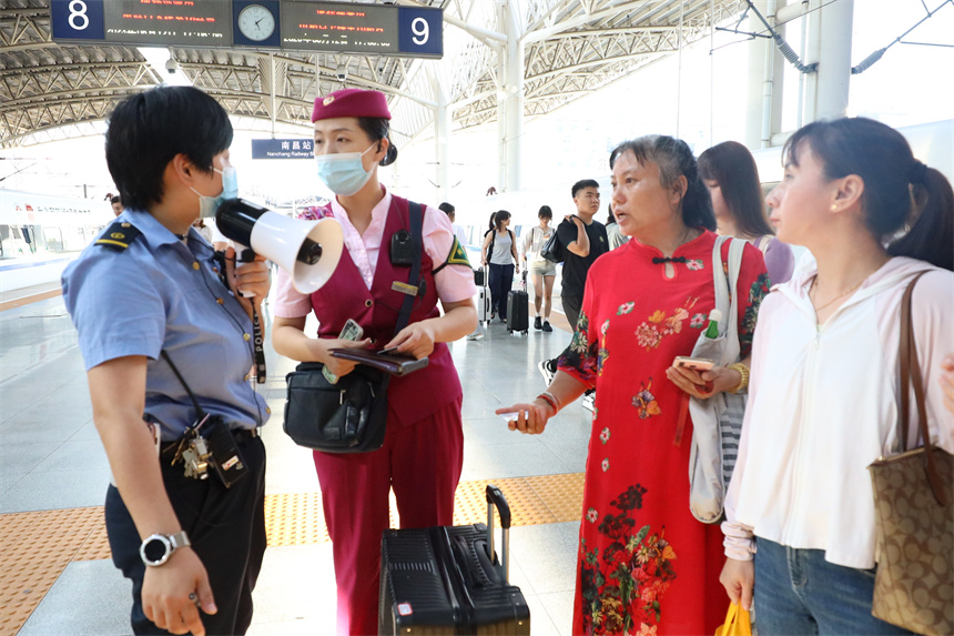 南昌客运段D6504次列车长王璐正在与车站值班员交接旅客。丁波摄
