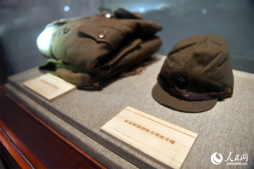 南昌新四军军部旧址陈列馆内展出的新四军缴获的日军战斗帽和军服。 人民网记者 时雨摄