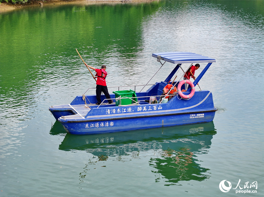近日，江西省赣州市安远县三百山东风湖，生态保洁员驾驶保洁船在清理水面漂浮物。人民网 朱海鹏摄
