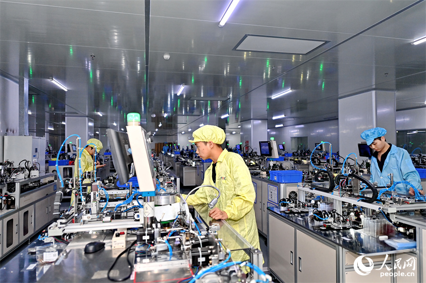 工作人員在全自動穿環機生產磁性元器件。人民網 朱海鵬攝