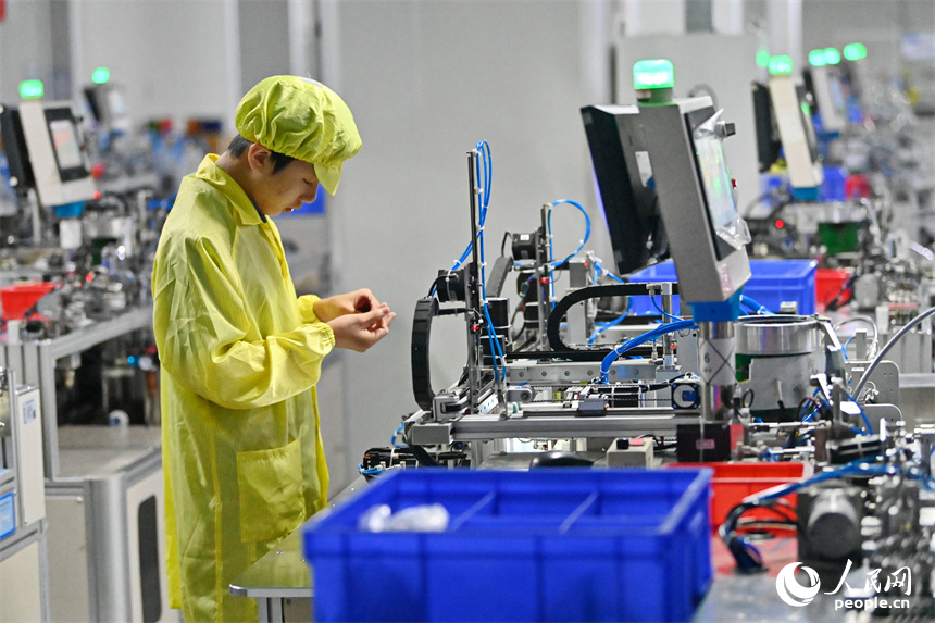 工作人員在全自動穿環機生產磁性元器件。人民網 朱海鵬攝